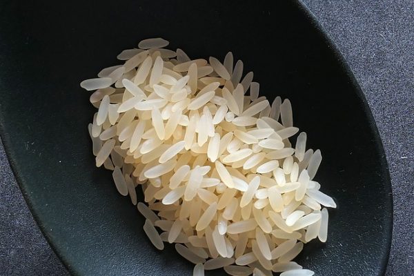 Auf einem Löffel liegt gekochter weißer Reis